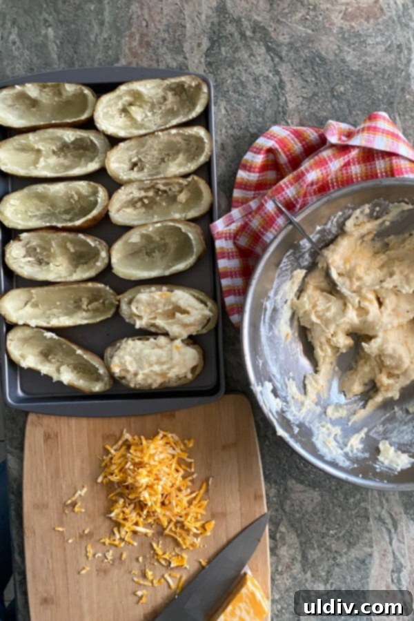 Make-Ahead Stuffed Potato Boats 4 Chef scooping rich, cheesy mashed potato filling back into potato skins.