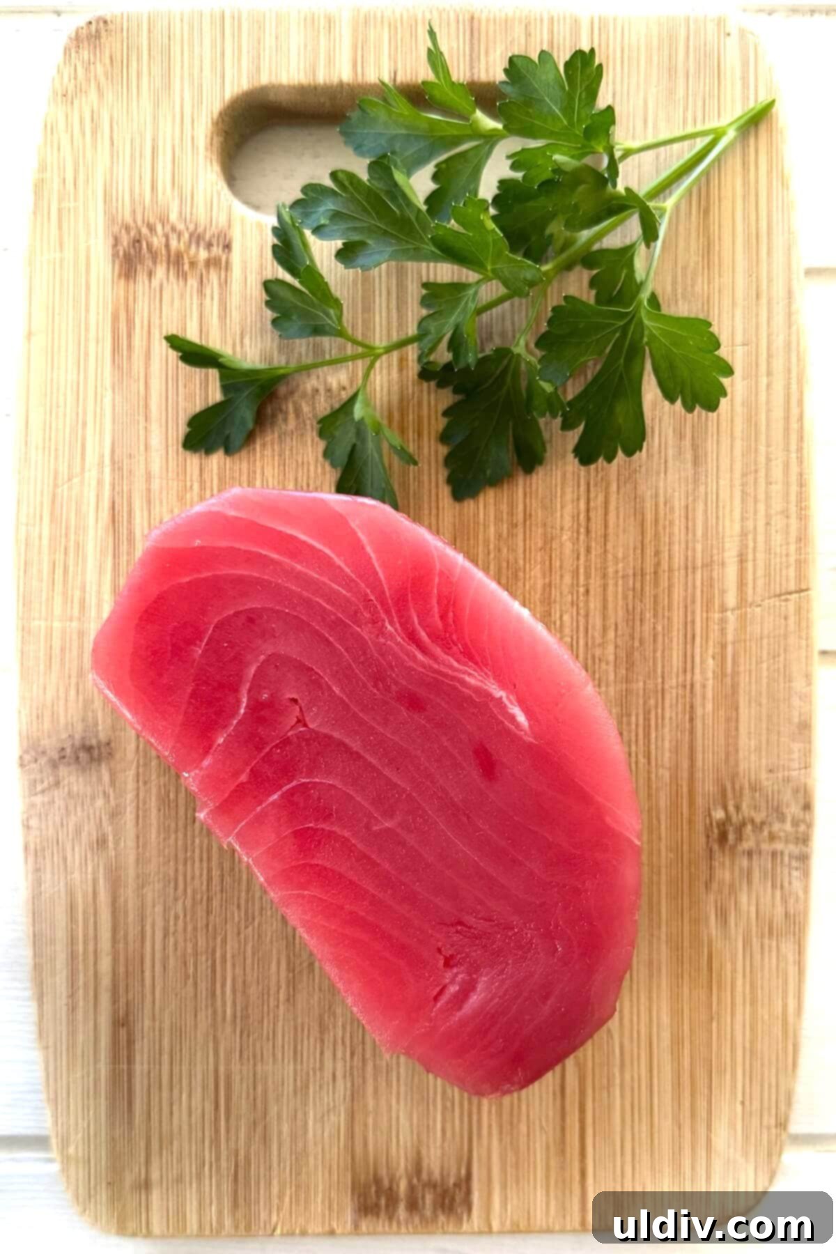 Fast and Fresh Tuna Ceviche 5 A perfectly portioned tuna steak on a wooden cutting board, ready for preparation.