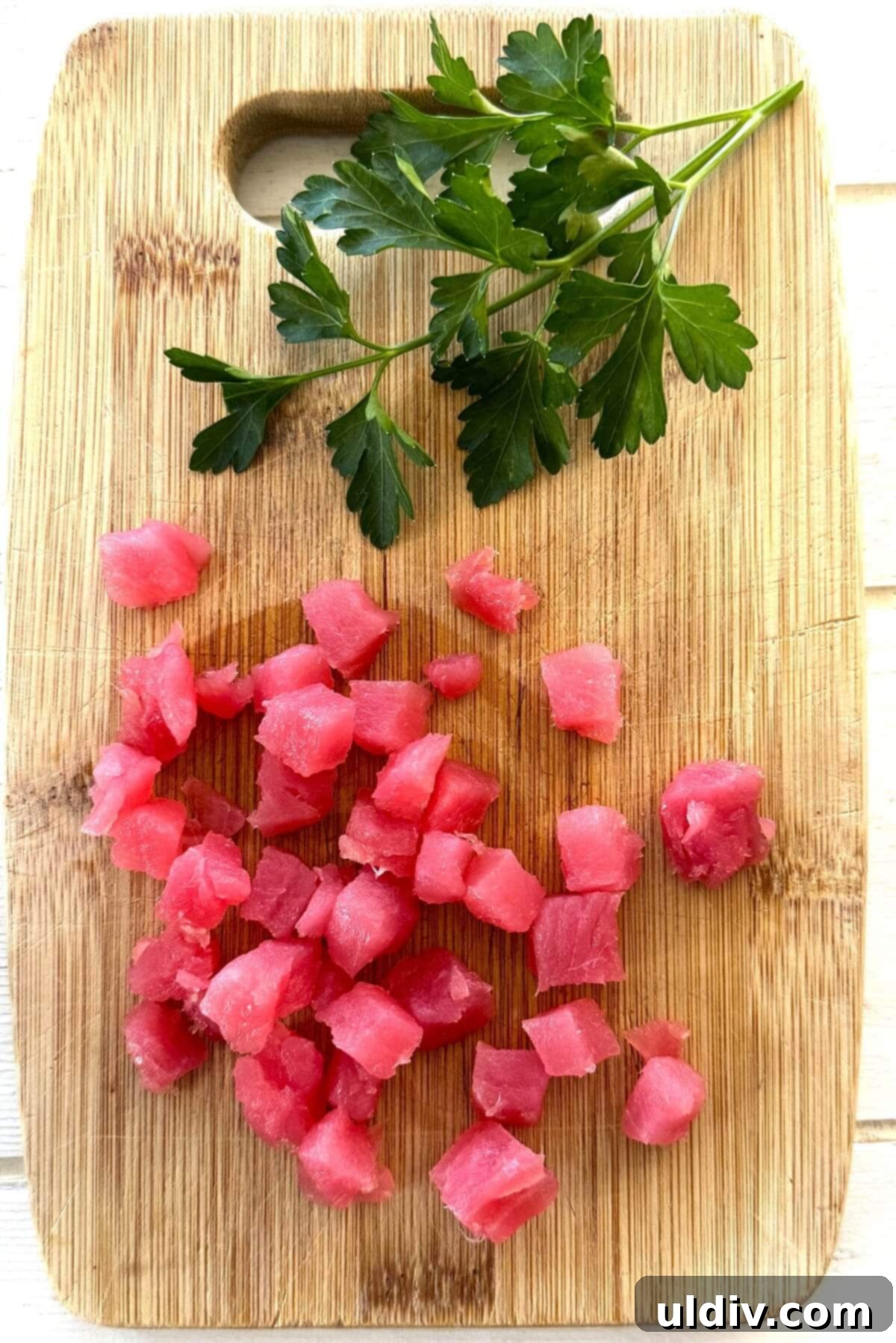 Fast and Fresh Tuna Ceviche 10 Precisely cut cubes of raw tuna on a clean cutting board, ready for the ceviche preparation.