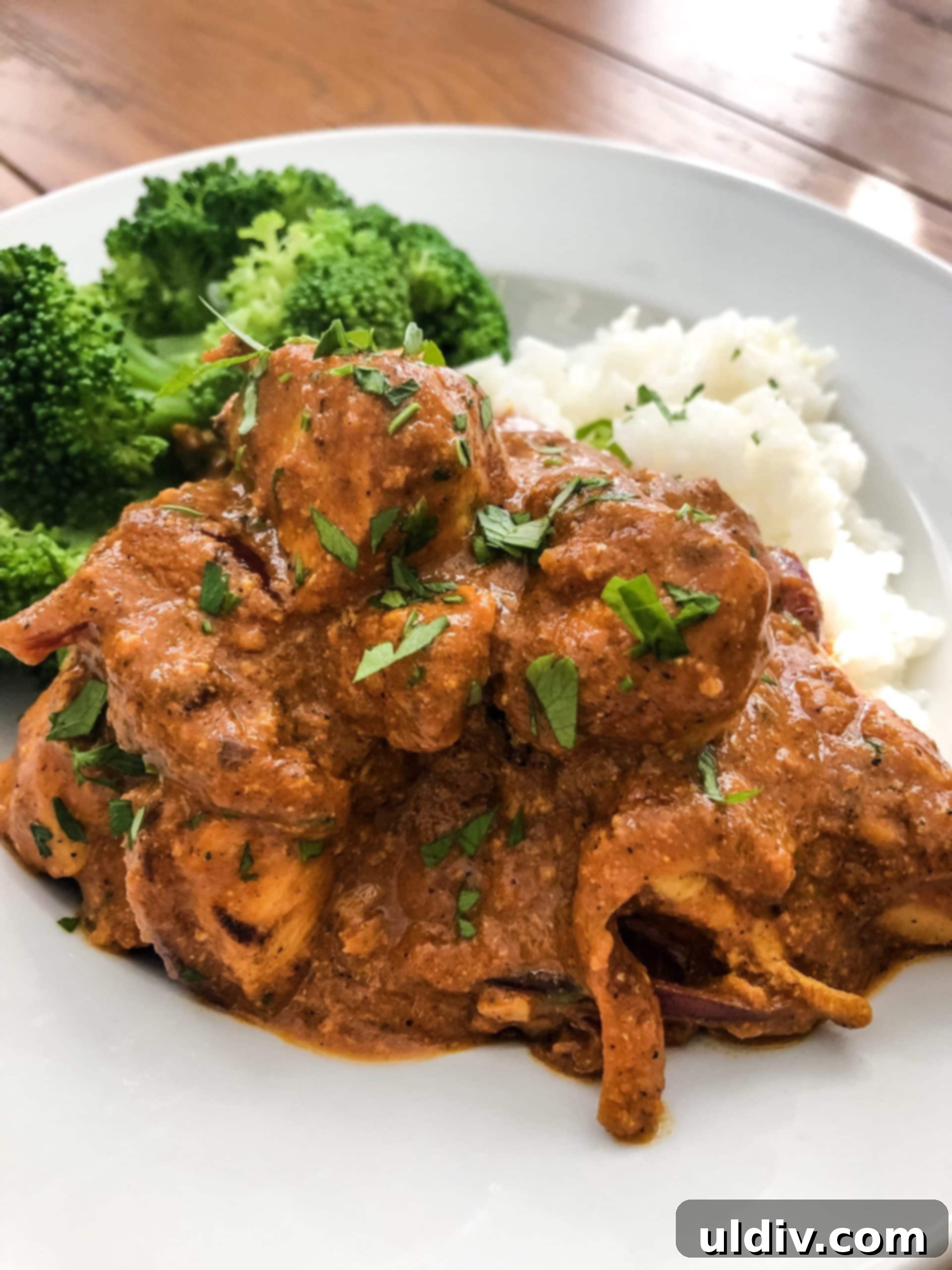 Golden Naan, Velvety Butter Chicken 2 Flavorful Naan with Butter Chicken served alongside basmati rice and steamed broccoli, showcasing a complete and appetizing meal.