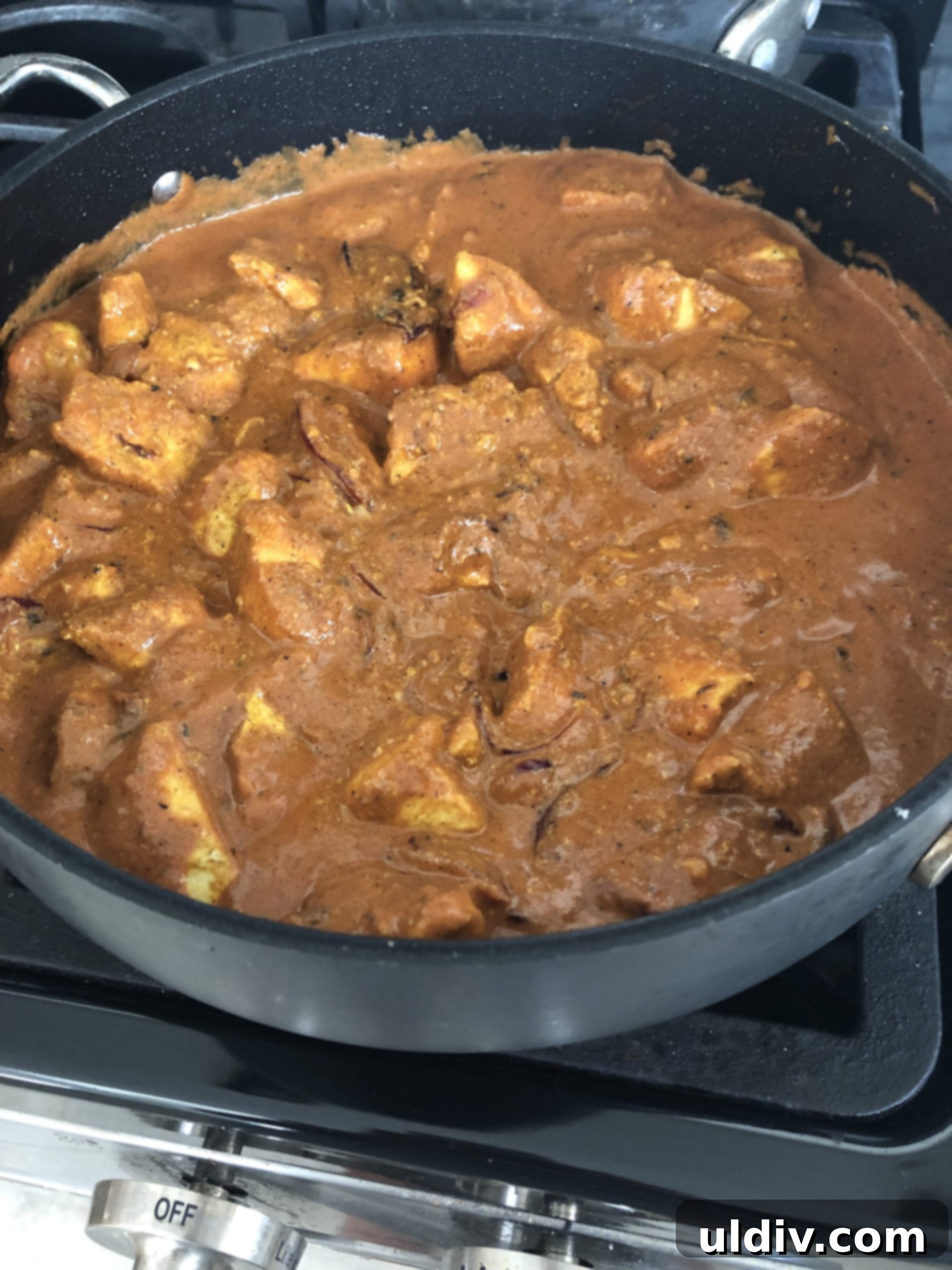 Golden Naan, Velvety Butter Chicken 7 Butter chicken simmering gently in its rich, creamy tomato sauce on the stovetop, allowing flavors to meld beautifully.