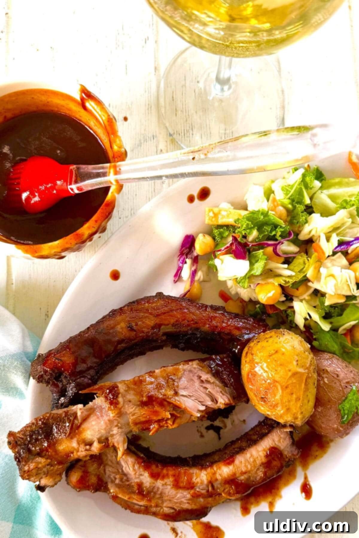 A delectable dinner plate featuring BBQ ribs, roasted potatoes, and a fresh green salad.