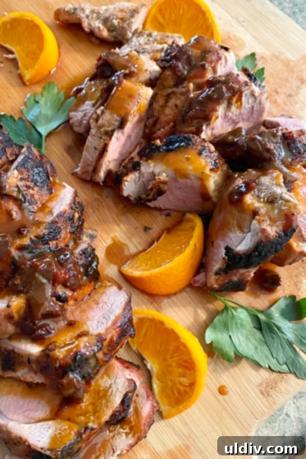 Tenderloin medallions with a glistening sweet and spicy chipotle, honey, and orange drizzle, alongside fresh orange segments.
