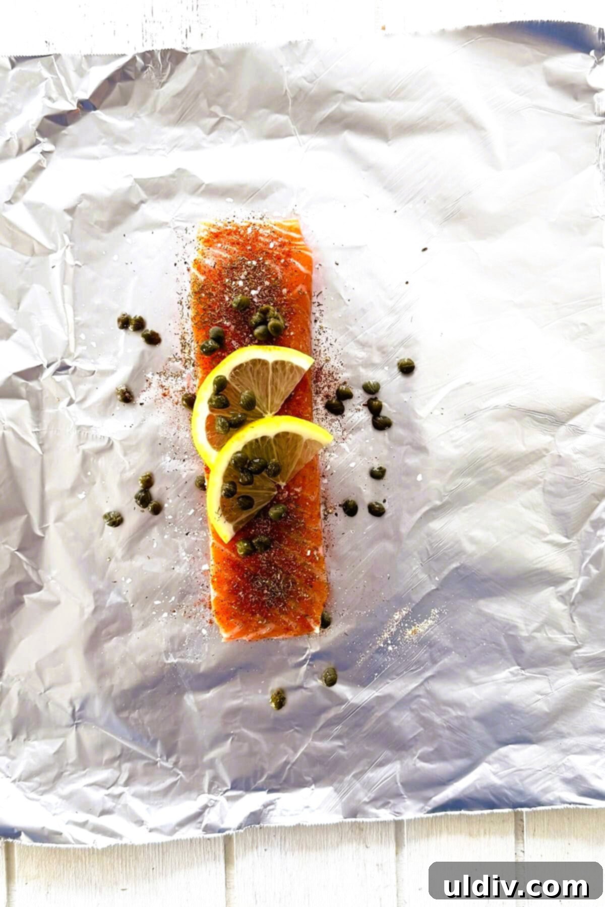 Quick and Healthy Foil-Baked Salmon 4 Salmon topped with spices, lemon and butter, ready to be wrapped.
