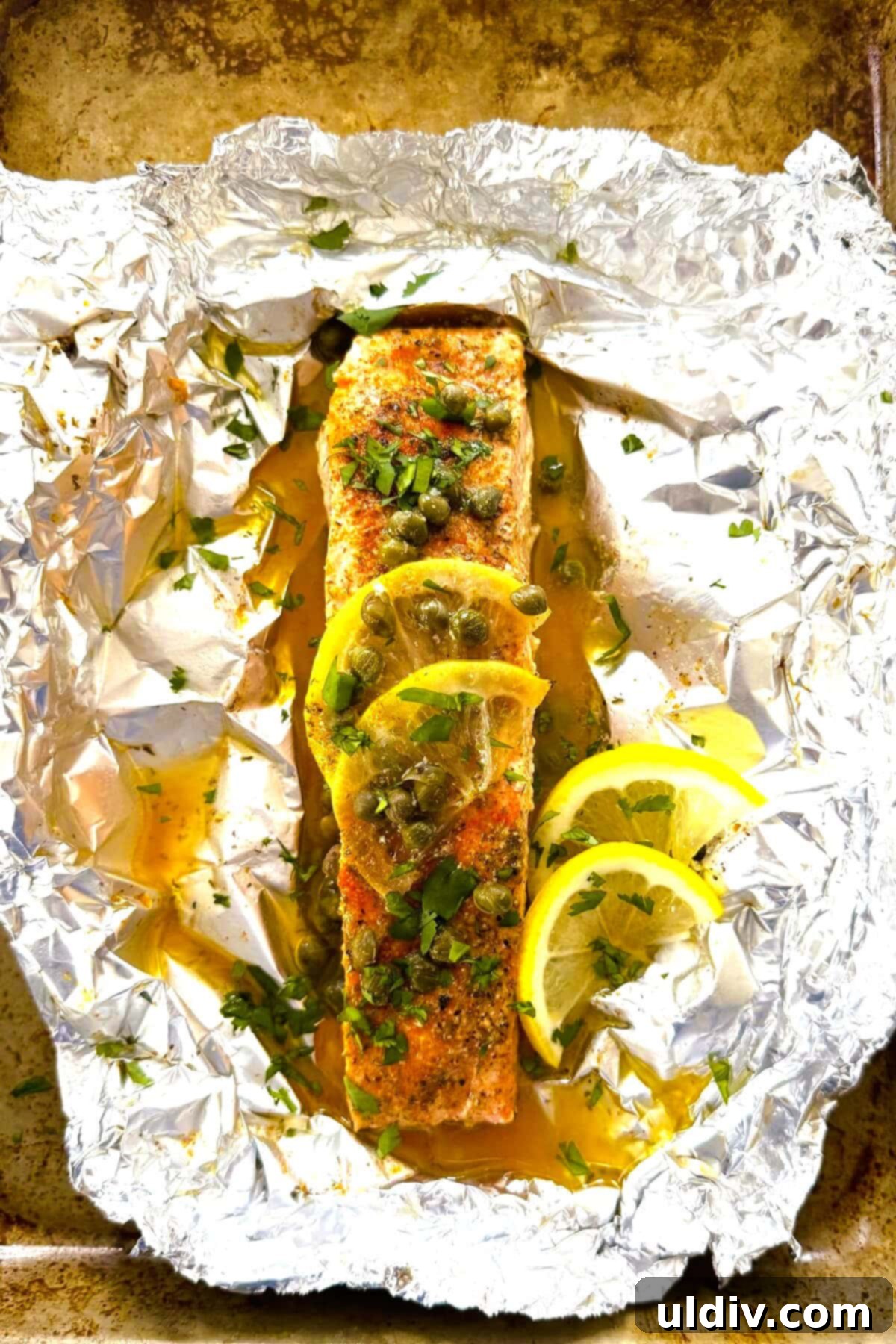 Quick and Healthy Foil-Baked Salmon 7 A perfectly baked piece of salmon with lemon and capers, glistening with sauce.
