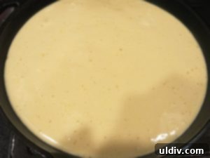Breaking In My New Cast Iron Skillet with Pineapple Upside-Down Cake 5 Cake batter spread evenly over pineapple slices in a skillet