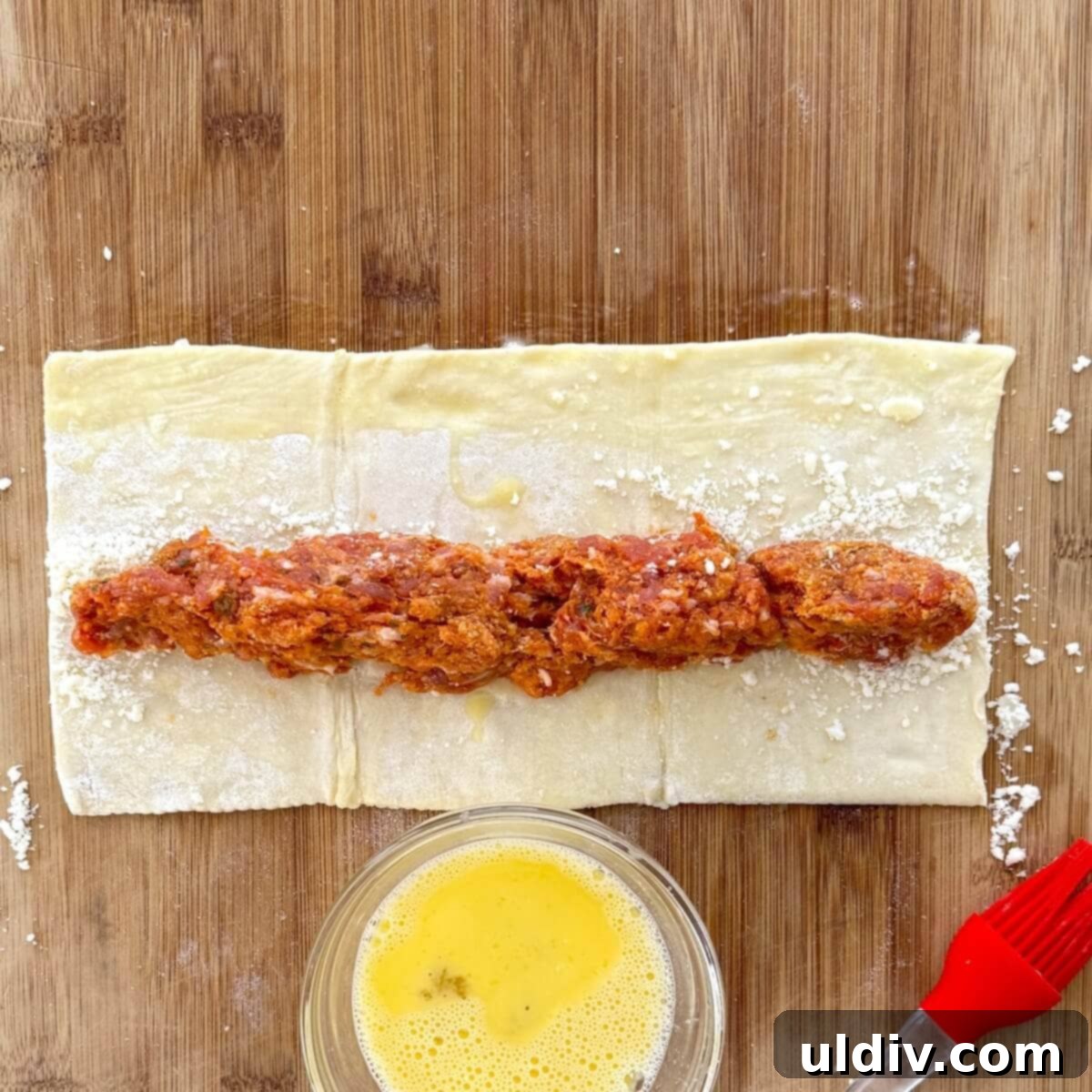 Homemade Pizza Sausage Rolls 8 Puff pastry with Italian sausage mixture formed into a log on top of the cheese.