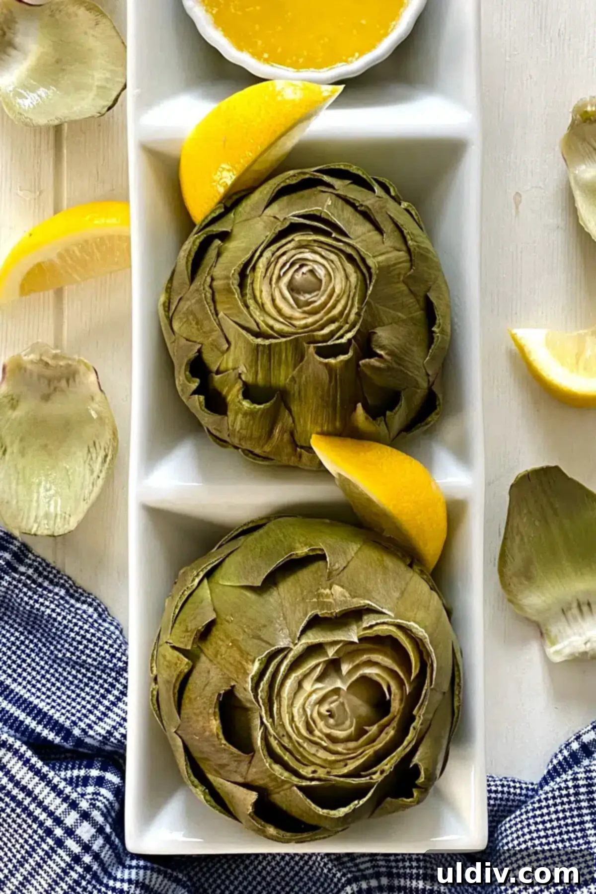 Microwave Magic: Artichokes in Minutes 2 Two perfectly cooked microwave artichokes with a fresh lemon wedge.