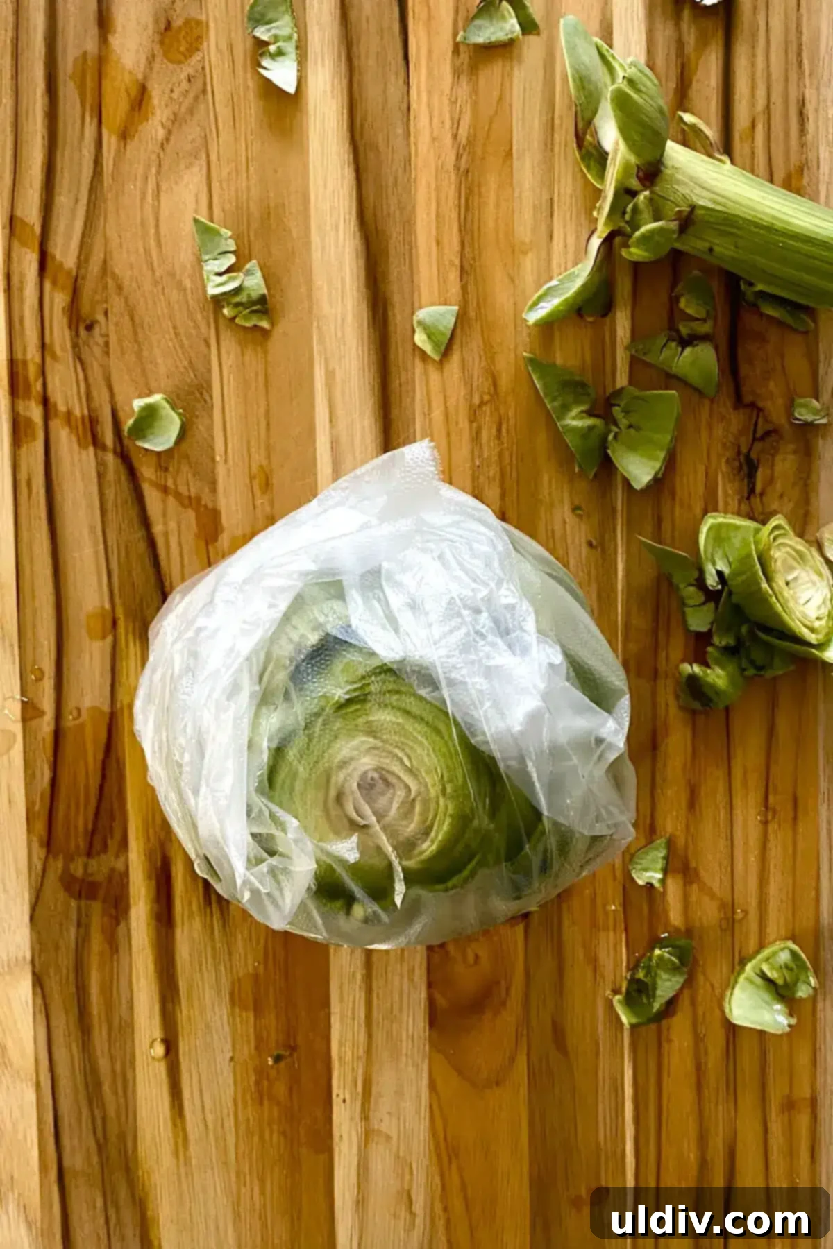 Quick & Easy Microwave Artichokes 7 A trimmed artichoke loosely wrapped in plastic wrap, ready for microwave cooking.