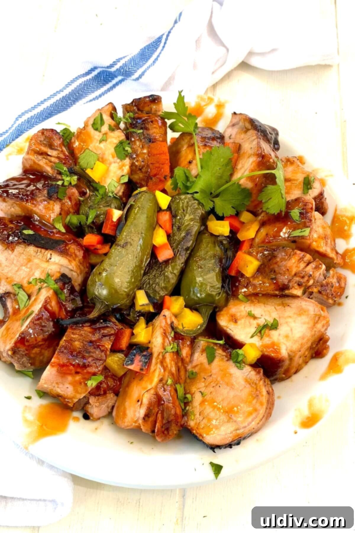 Sweet Heat Pork Tenderloin 12 pork on a plate with peppers.