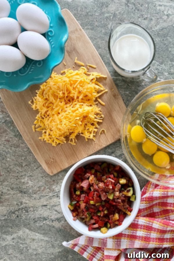 Effortless Sausage Spinach and Cheddar Breakfast Bake 4 A vibrant assortment of fresh ingredients laid out, including breakfast sausage, fresh spinach, large eggs, a carton of milk, a block of cheddar cheese, and a jar of Dijon mustard, all ready for preparing an easy breakfast casserole.
