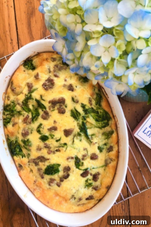 Effortless Sausage Spinach and Cheddar Breakfast Bake 5 A vibrant, baked breakfast casserole featuring sausage, spinach, and cheddar cheese, fresh out of the oven, presenting a golden-brown top and bubbly edges, ready to be sliced and served.