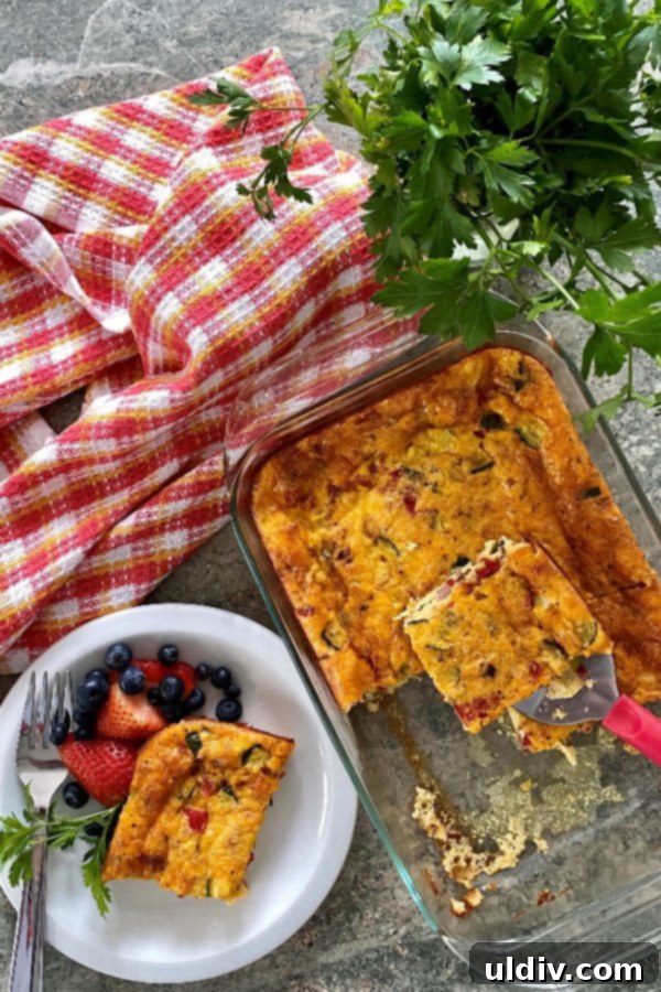 Effortless Sausage Spinach and Cheddar Breakfast Bake 8 A beautifully presented, golden-brown breakfast casserole, brimming with savory ham, sweet onions, sharp cheddar cheese, vibrant red pepper, and tender zucchini, showcasing a generous slice ready to be served.