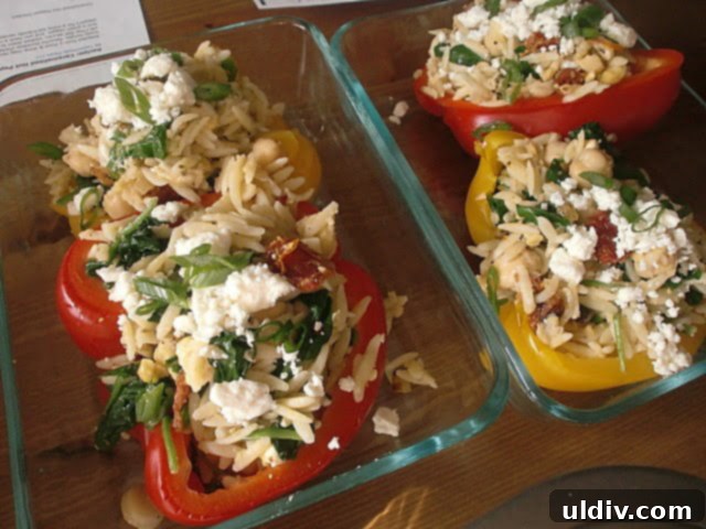 Sun-Drenched Greek Orzo Feta Stuffed Peppers 2 Orzo and feta stuffed peppers in pyrex.