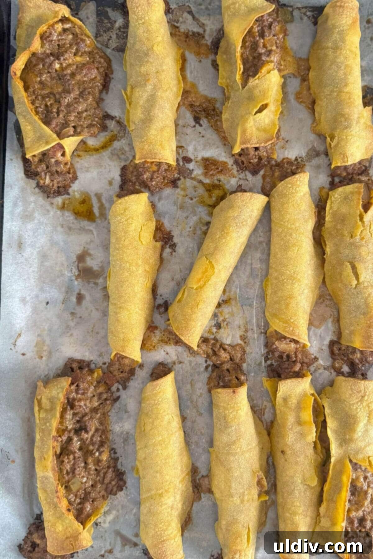Crispy Baked Taquitos 12 A baking sheet showing beef and cheese taquitos that have burst open during baking, illustrating a common issue.