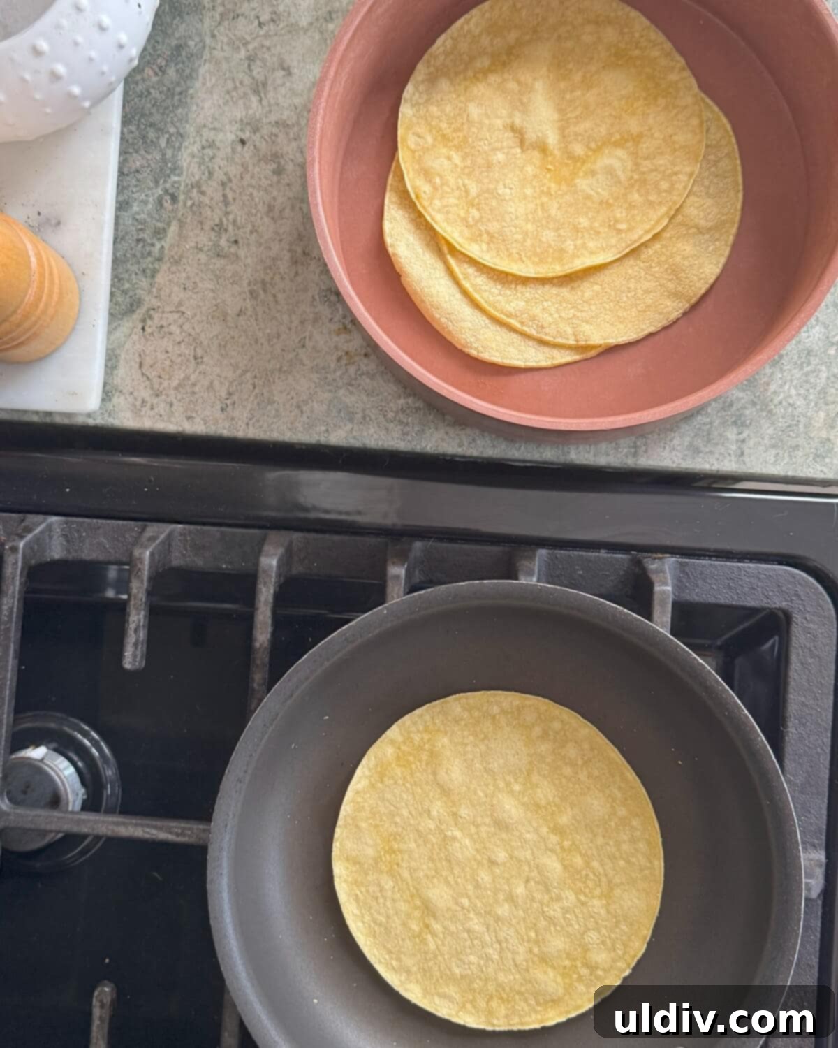 Crispy Baked Taquitos 7 Warming corn tortillas in a pan and a stack of warmed tortillas in a tortilla warmer, emphasizing proper tortilla preparation.