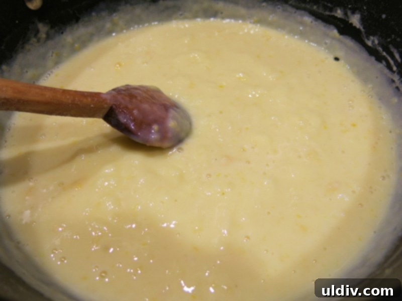 Eclairs Sweet Delights 4 Pastry cream being prepared in a saucepan on the stovetop, whisked to a smooth consistency.