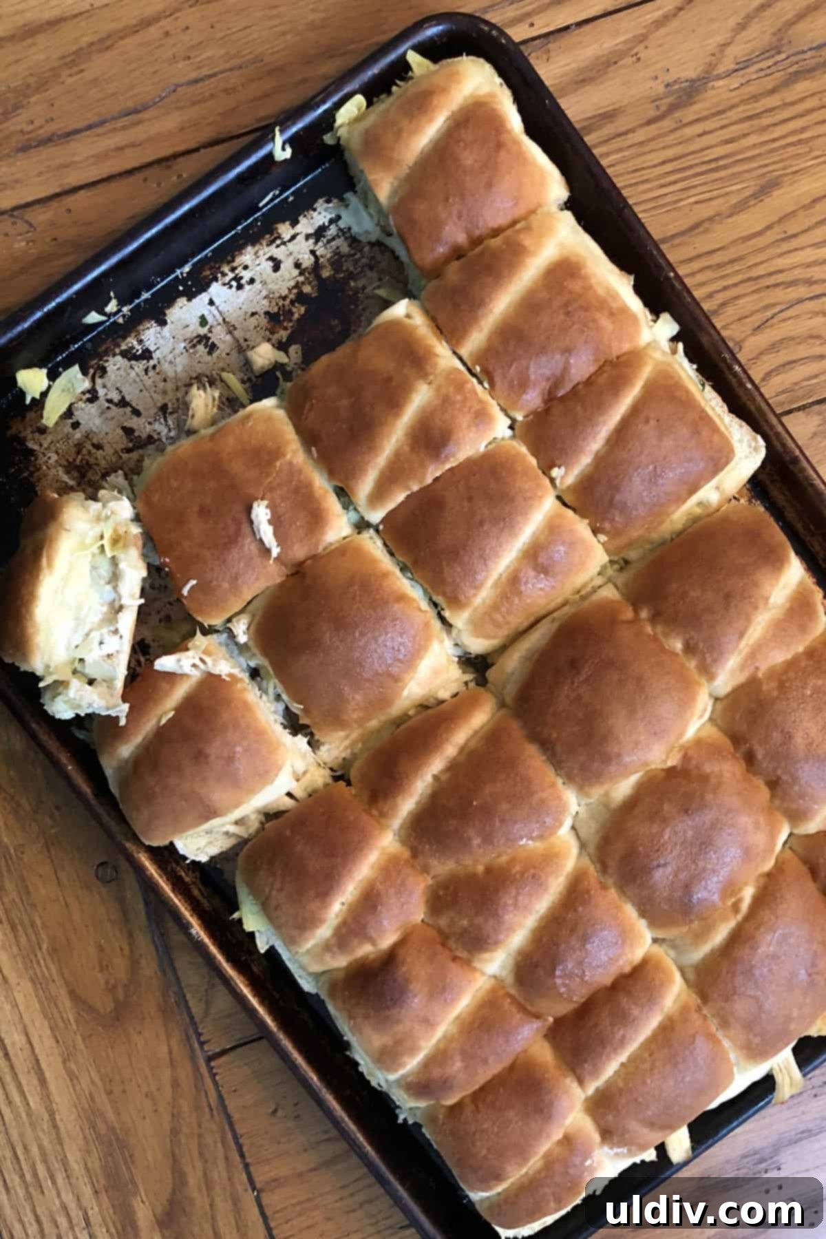 Melty Turkey Sliders with Dreamy Artichoke Dip 4 A close-up view of a pan of cheesy turkey sliders, freshly baked and ready to eat.