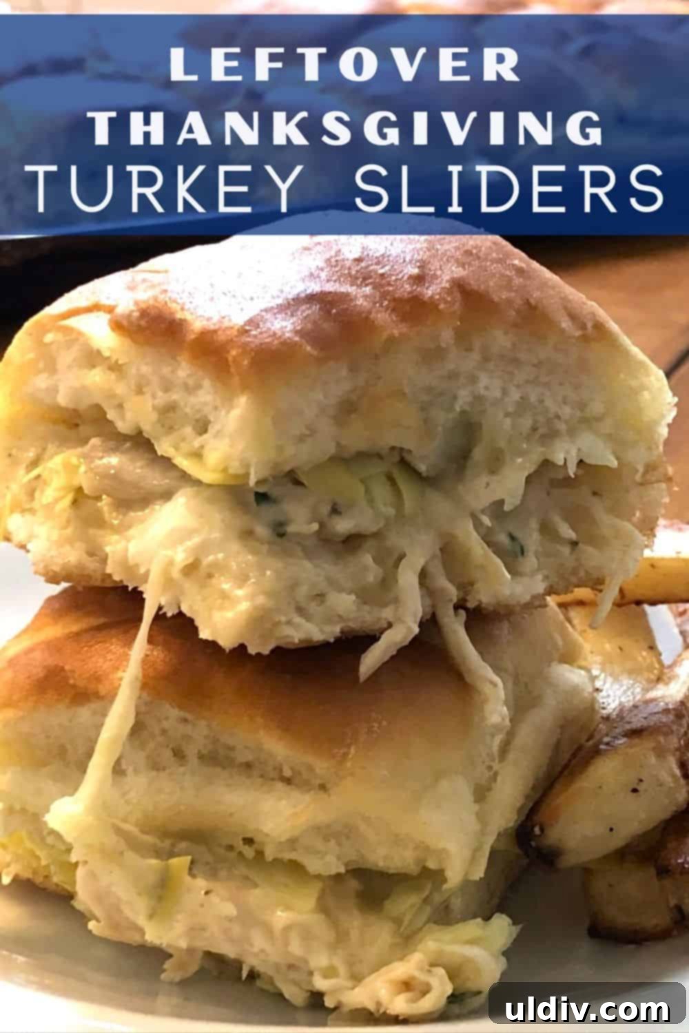Melty Turkey Sliders with Dreamy Artichoke Dip 5 A plate of two juicy turkey sliders garnished with fresh parsley.