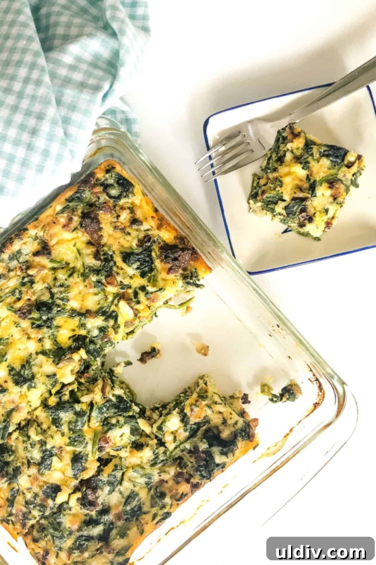Crustless Spinach Bacon Egg Bites 4 A crustless spinach quiche with several slices already cut out and ready for serving.