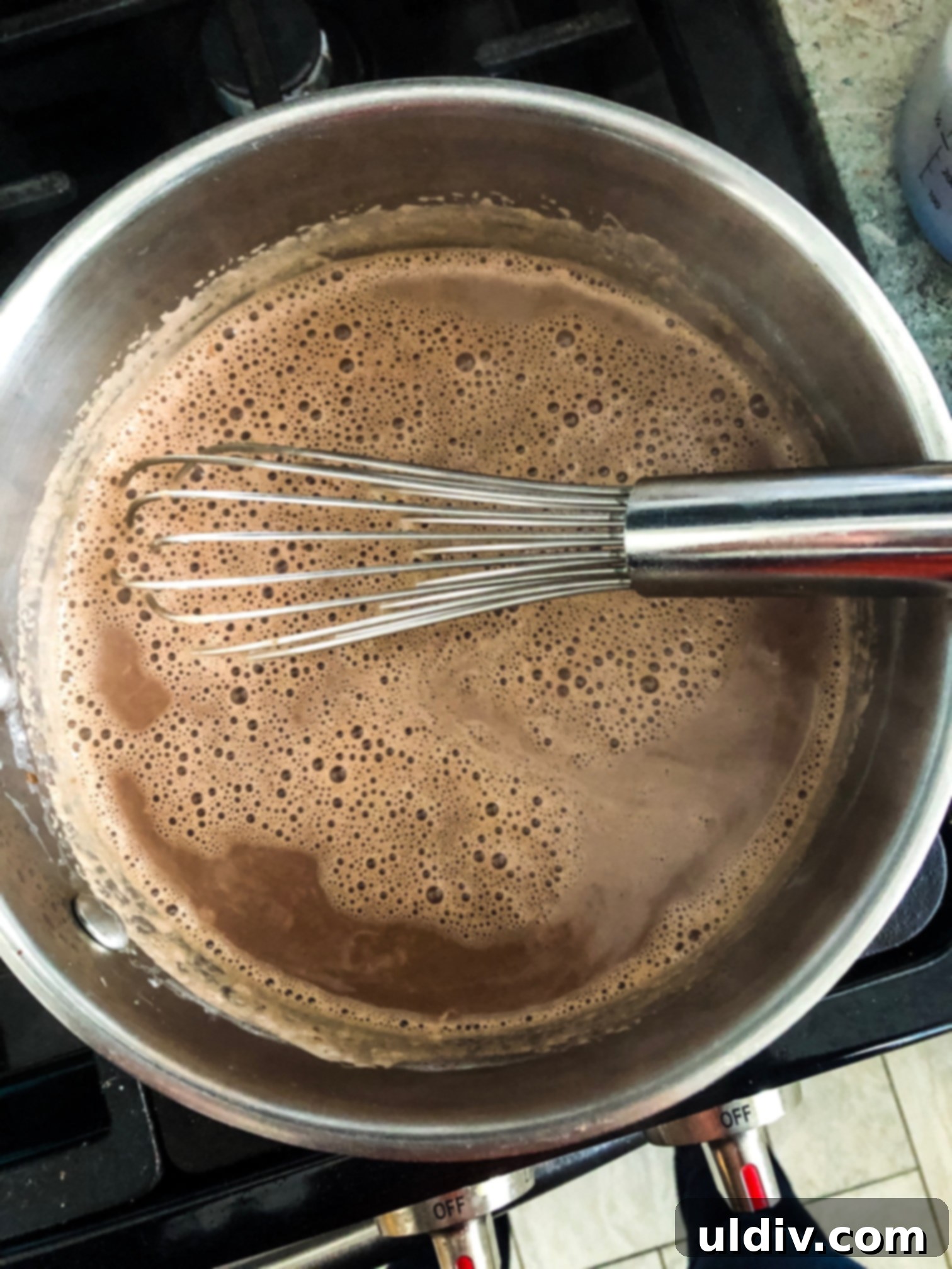 Indulgent Hot Chocolate Blend 5 simmering pot of hot cocoa with a whisk