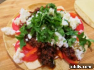 Cinco de Mayo Weekend Double Stacked Tortilla Sandwich Feast 8 First corn tortilla stack nearing completion with crumbled queso fresco and chopped cilantro.