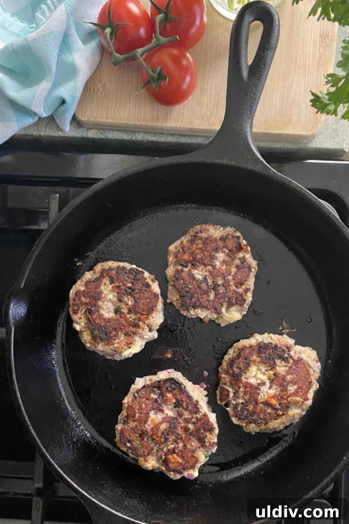 Cooking flavorful Greek turkey burgers to golden perfection in a sizzling cast iron skillet.