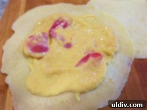 Sweetest Mom, Sweetest Treat: Decadent Mango Crepes for Mother's Day 12 Spreading mango and strawberry filling evenly on a crepe