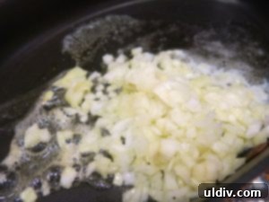 Chopped onions sautéing in a pan with melted butter
