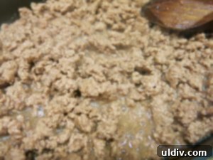Ground chuck browning in a pan until thoroughly cooked