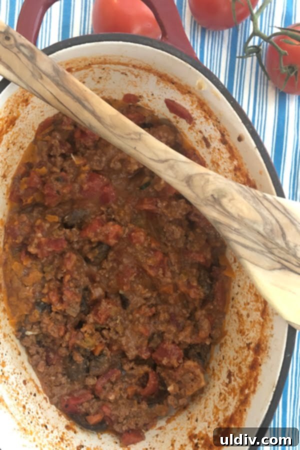 Effortless Pancetta Bolognese 3 A close-up of a rich Italian meat sauce, Bolognese, simmering in a pot, ready to be served over pasta.
