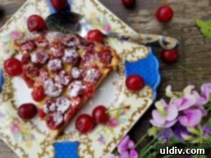 Sour Cherries: Summer's Ruby Legacy of Flavor 11 A baked sour cherry clafoutis, golden brown and garnished, presented in a quiche dish, ready to be served.