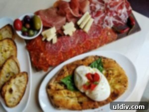 Forno Rosso Pizzeria: Pizza or Panuozzo? Why Not Both! 6 An enticing plate of salumi misti with cured meats, cheeses, and olives, highlighting prosciutto and capicola.