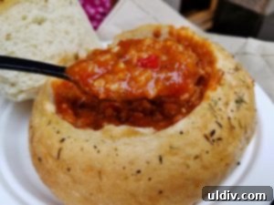A hearty bowl of overstuffed bell pepper soup in an Italian herb bread boule.