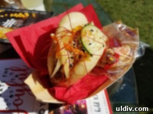 A Decade of Deliciousness: Chicago Gourmet 18 An exquisite Asian BBQ duck steamed bun from Joy District, garnished with pickled vegetables and cilantro, a true culinary highlight.