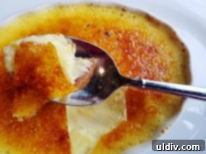 Close-up of the rich and creamy vanilla bean crème brûlée after breaking the crust