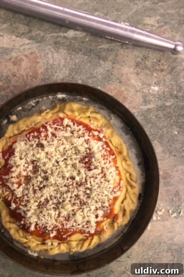 Mastering Authentic Stuffed Pizza 5 An unbaked deep dish pizza, showing the thick crust lining the pan and ready for baking.
