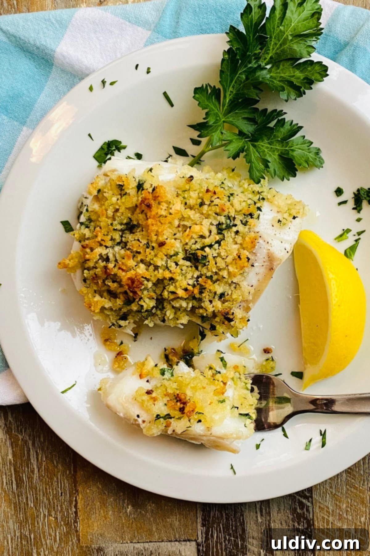 Golden-Crisp Garlic Herb Panko Baked Cod 2 A fork lifting a perfect piece of baked cod with a golden, crispy panko crust, showing the flaky white fish underneath.