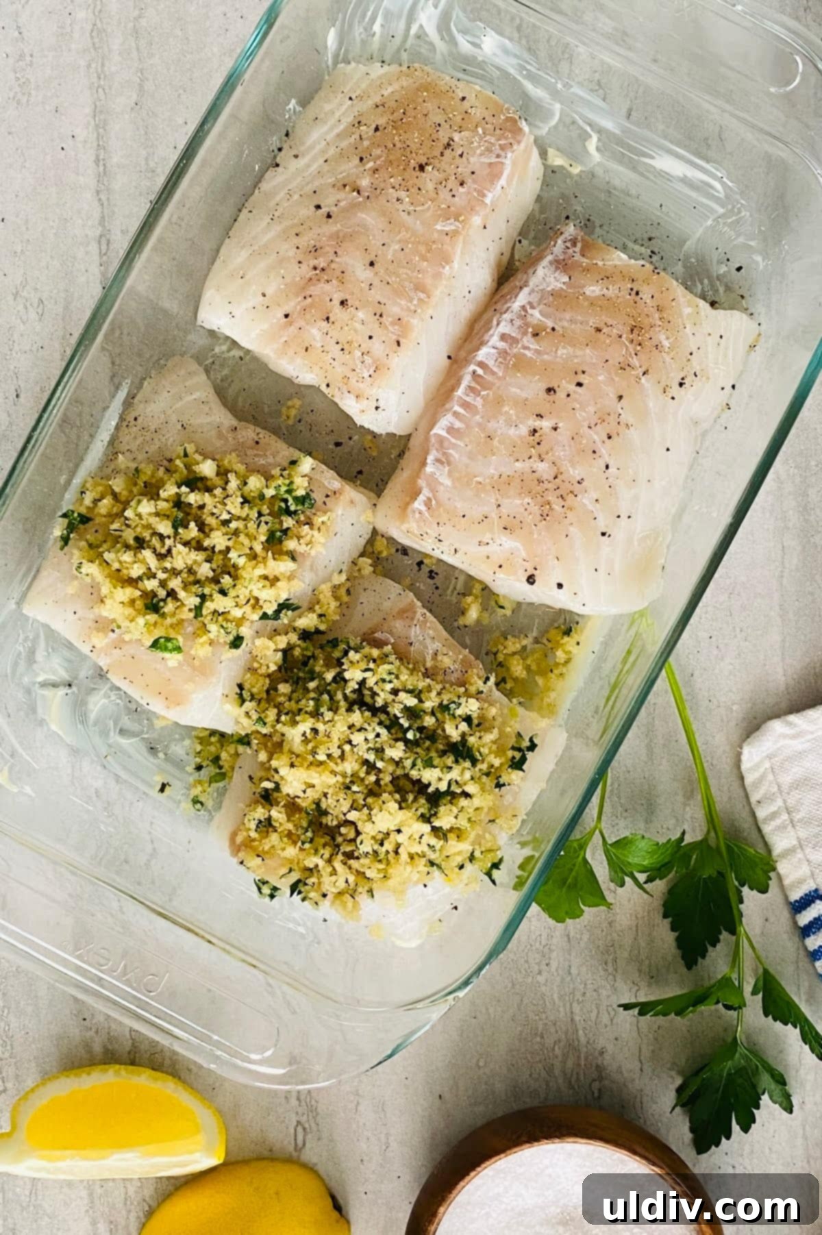 Golden-Crisp Garlic Herb Panko Baked Cod 8 Two unbaked cod fillets generously topped with the buttery garlic herb panko mixture, waiting to be transferred to the oven.