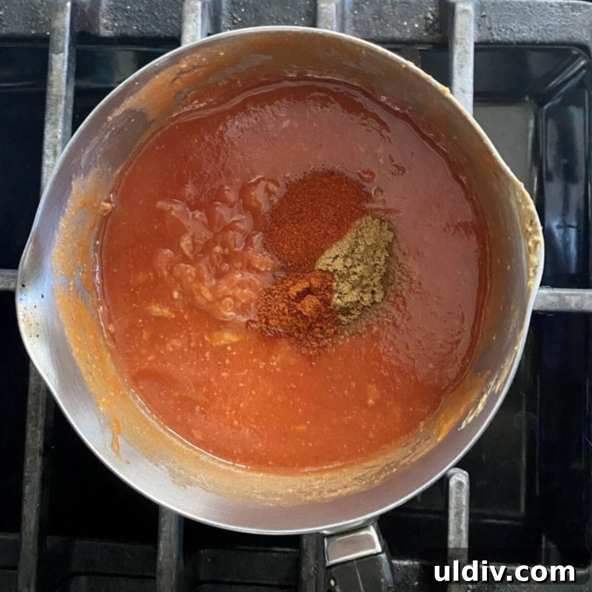 Effortless Healthy Black Bean Enchiladas 4 Rich, red enchilada sauce simmering gently in a small pot, creating an aromatic base for the enchiladas.