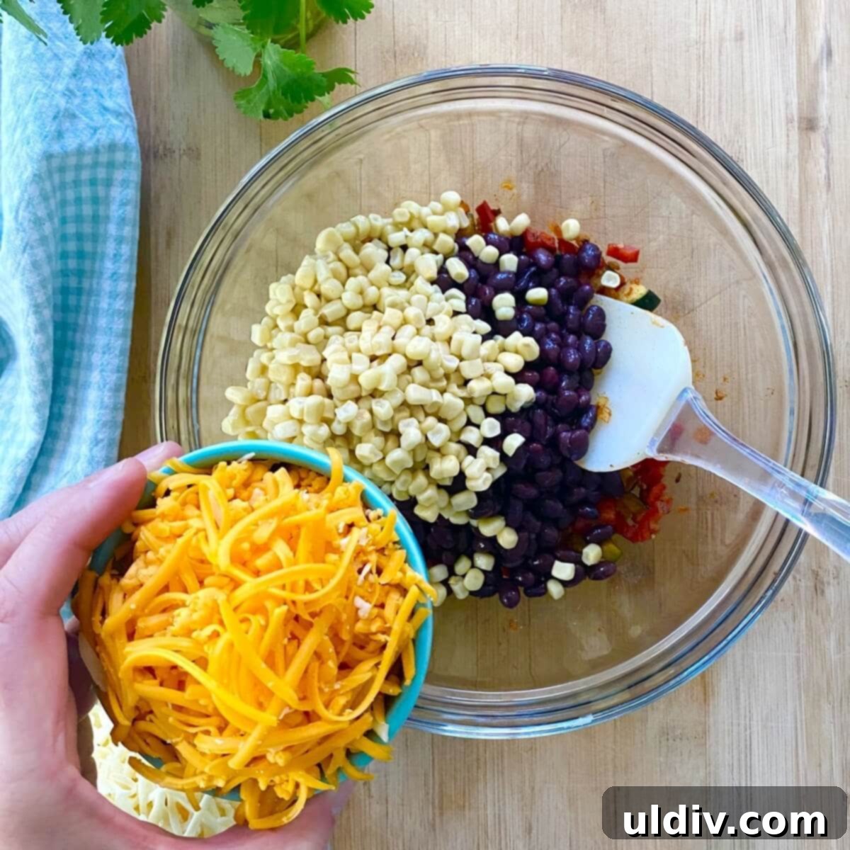 Effortless Healthy Black Bean Enchiladas 6 A vibrant bowl filled with shredded cheeses, golden corn kernels, and dark black beans, ready to be mixed into the vegetable sauté.