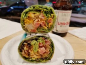 Square Roots Kitchen Redefining Fast Casual for Food Geeks 6 Chicken BLT Wrap in a spinach tortilla, showcasing its fresh ingredients.