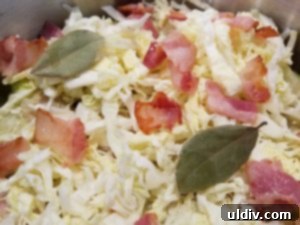 Easter's Heartwarming Cabbage Rolls A Tale of Tradition 11 Final layers of cabbage rolls, shredded cabbage, bacon, and bay leaves in the pot