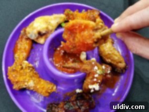 WingFest 2018 A Flavorful Dash Against Time 7 A close-up of a plate filled with various chicken wings, showcasing different sauces and garnishes from WingFest vendors.