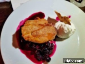 A perfectly plated apple fritter with a vibrant charred blueberry compote, a dessert prepared by Chef Ryan Rondeno during the Culinary Fight Club The Final Plate competition.