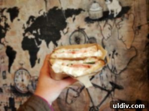 Coffee Joint's Mozzarella & Basil sandwich, featuring fresh burrata, ripe tomatoes, creamy cheese, and fragrant basil on toasted multigrain bread.