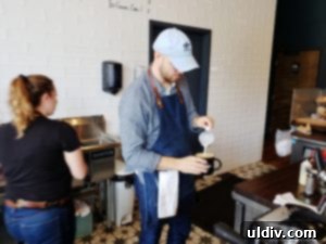 World-Class Coffee & Sandwiches: Exquisite Flavors, Just Around the Corner 5 Skilled barista expertly preparing coffee behind the espresso machine, showcasing the artistry and dedication to quality at Coffee Joint.