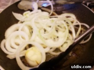 Onion rings browning in the pan with harissa traces