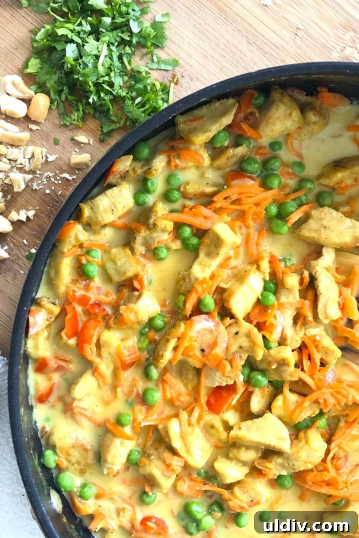 Velvety Thai Coconut Chicken Curry 2 sauté pan with Thai chicken with peas.