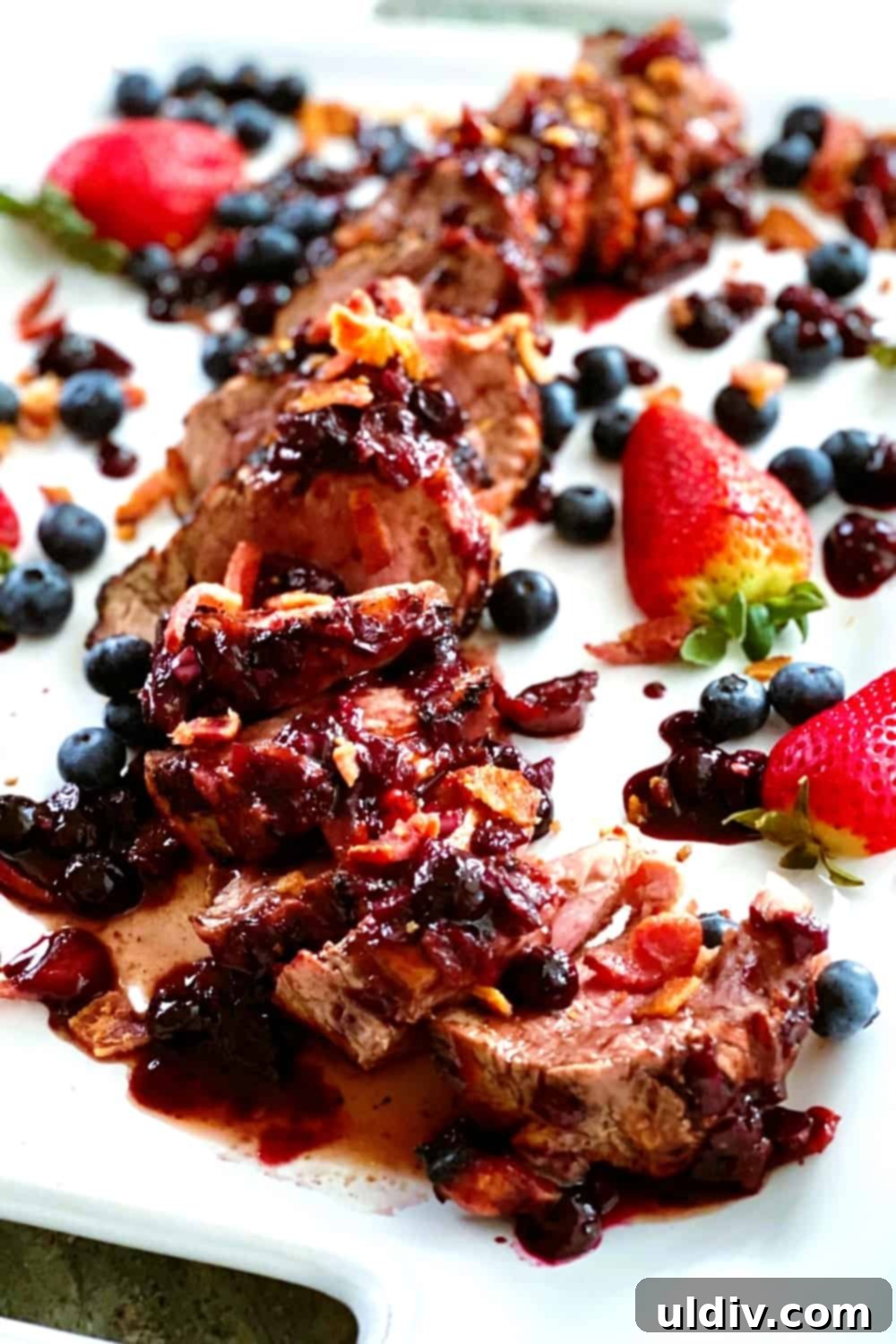 Berry Bacon Glazed Grilled Pork Tenderloin 2 Perfectly sliced grilled pork tenderloin drizzled with luscious berry bacon sauce, ready to be served.